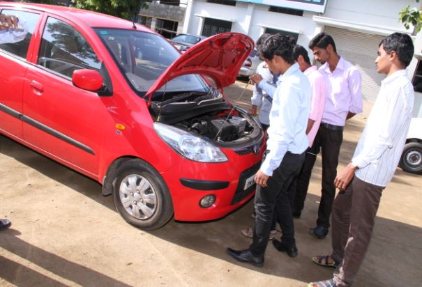 Students inspecting a vehicle engine